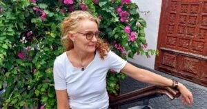 Barbara Kast vor einem Tor mit Bougenvillen